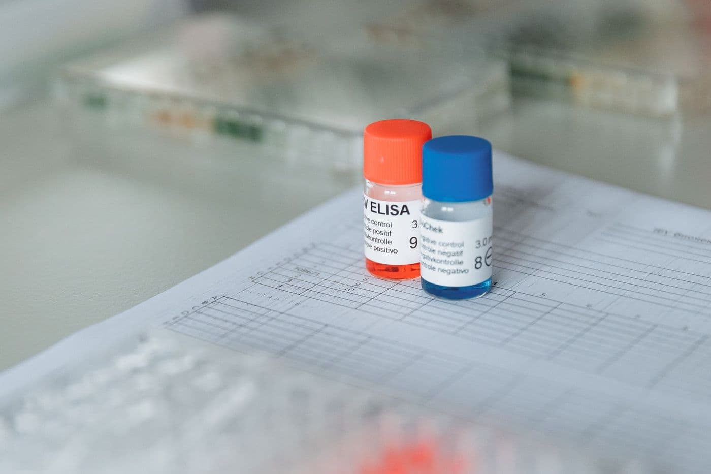 Small reagent vials on a laboratory bench beside a sample plate.