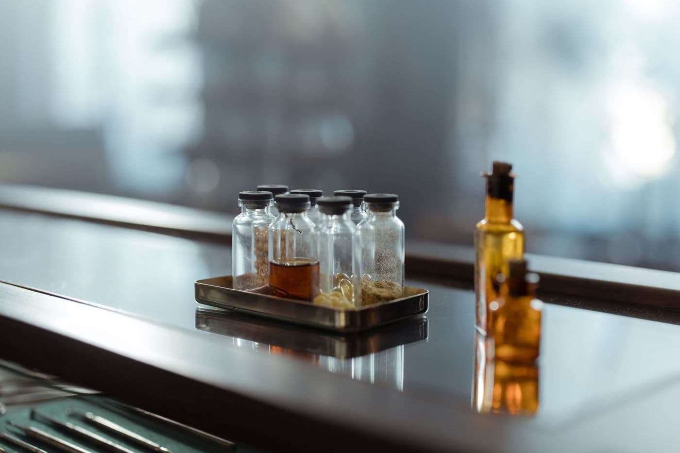 Sealed vials standing on a dark reflective bench.